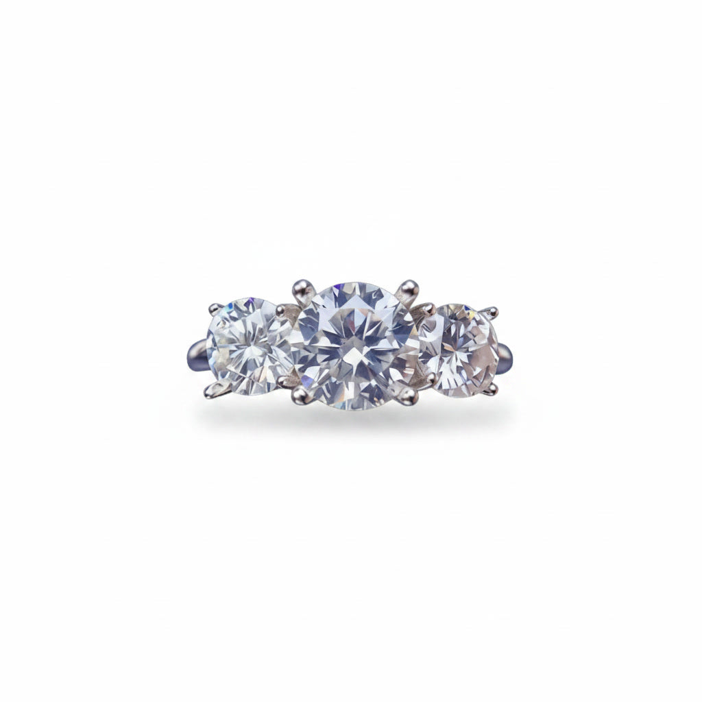 Three stone white moissanite ring featuring a 1 carat round center stone with two 0.5 carat side stones in solid sterling silver with platinum plating.