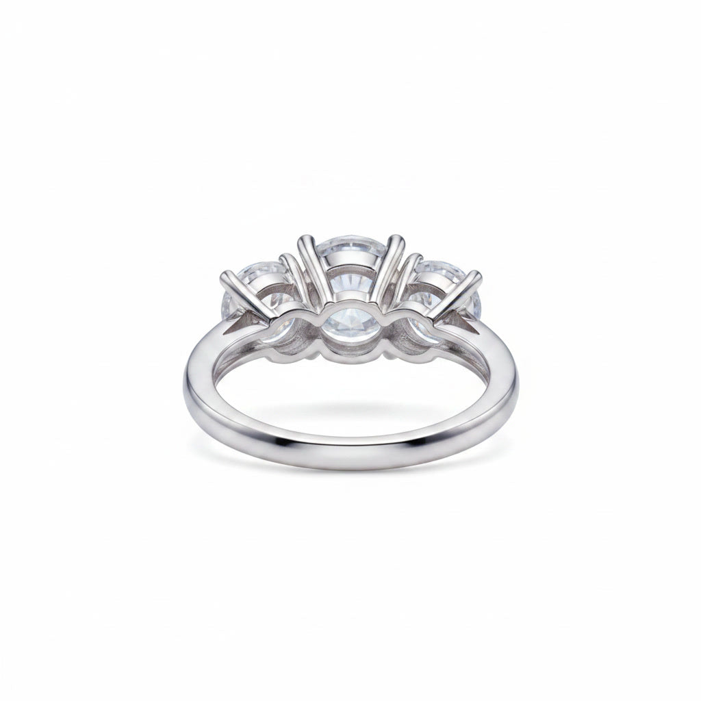 Three stone white moissanite ring featuring a 1 carat round center stone with two 0.5 carat side stones in solid sterling silver with platinum plating.