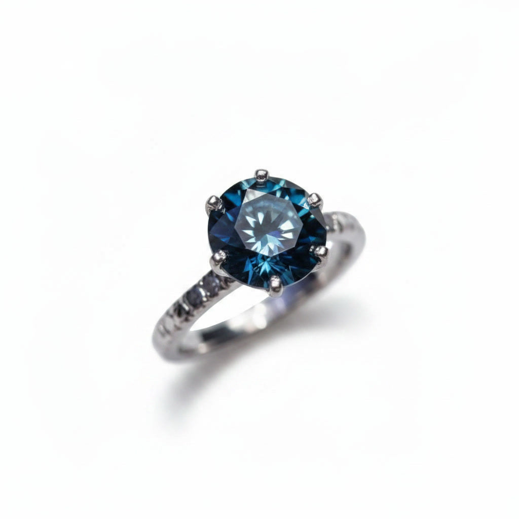 2 carat dark blue round moissanite solitaire ring in platinum plated 925 sterling silver on a white background