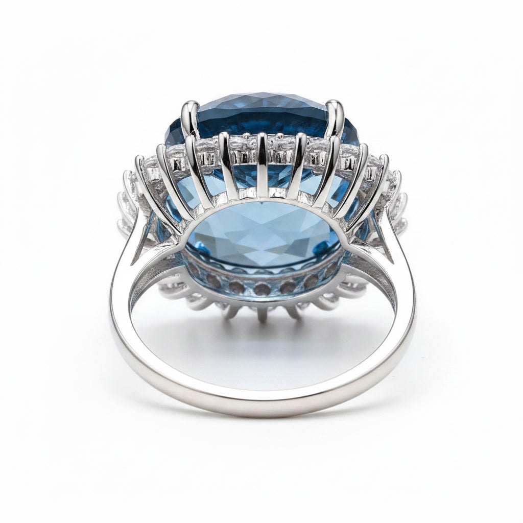 12ct Firework Cut London Blue Topaz halo statement ring featuring a 15mm round genuine London Blue Topaz, sparkling clear cubic zirconia halo, polished 925 sterling silver setting, and custom platinum, gold, or rose gold finish