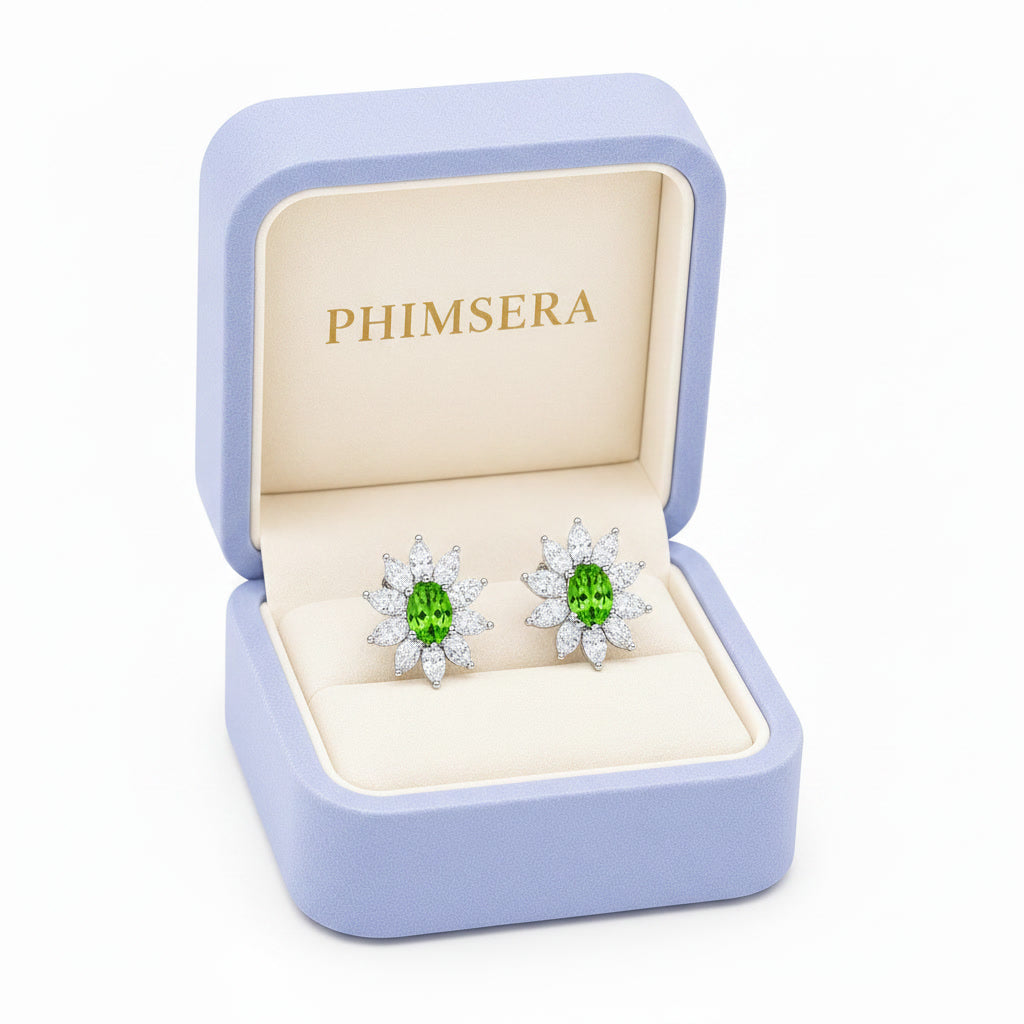Natural 4x6mm oval tsavorite halo stud earrings in 925 sterling silver with marquise cubic zirconia floral halo on a white background