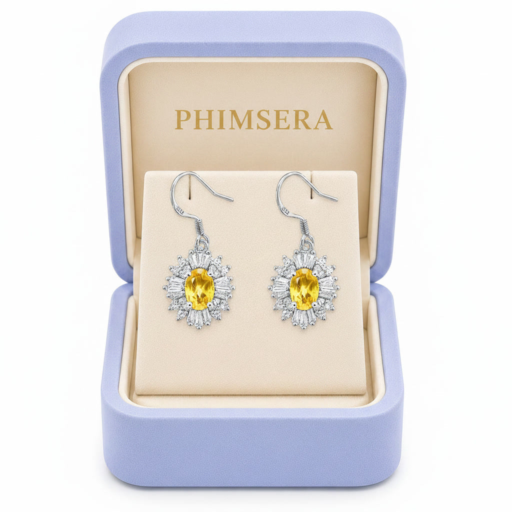 Natural 4x6mm oval citrine halo drop earrings crafted in 925 sterling silver on a pure white background in Phimsera box.