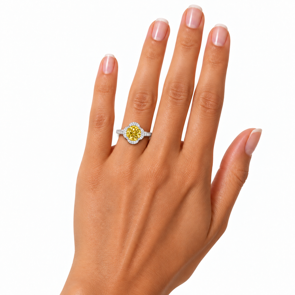 Alternate hand model photograph of an 8mm yellow moissanite ring on a woman's ring finger, showing realistic gemstone proportions, four-petal halo and delicate sterling silver band.