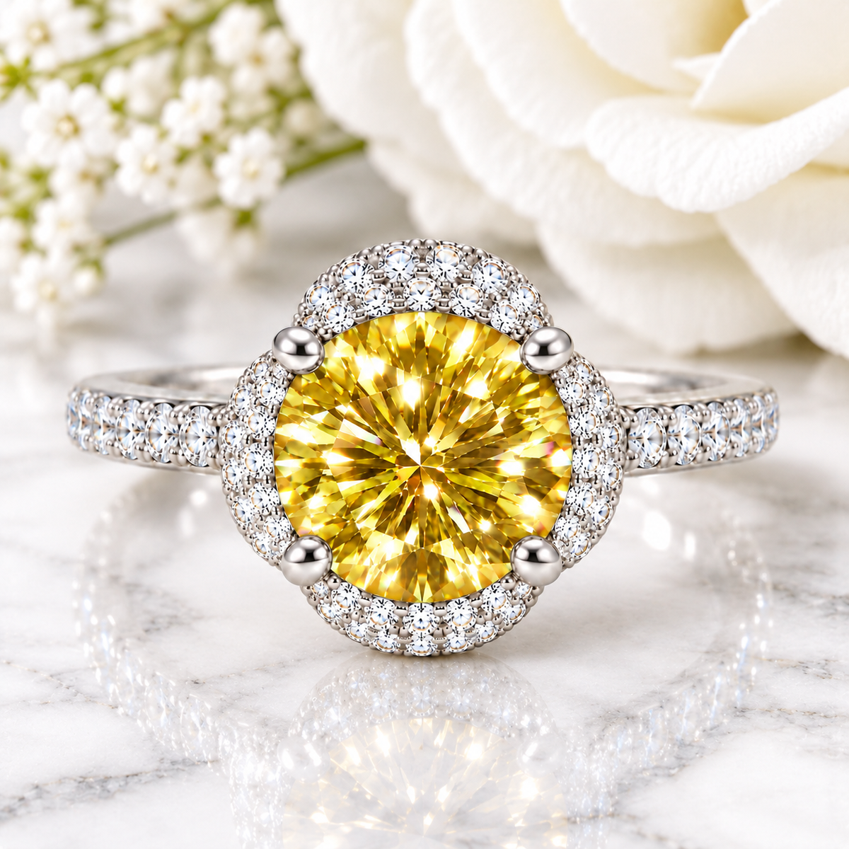 A radiant yellow diamond ring with a halo of small diamonds on a silver-toned band, set against a soft white rose and baby's breath on a marble surface.