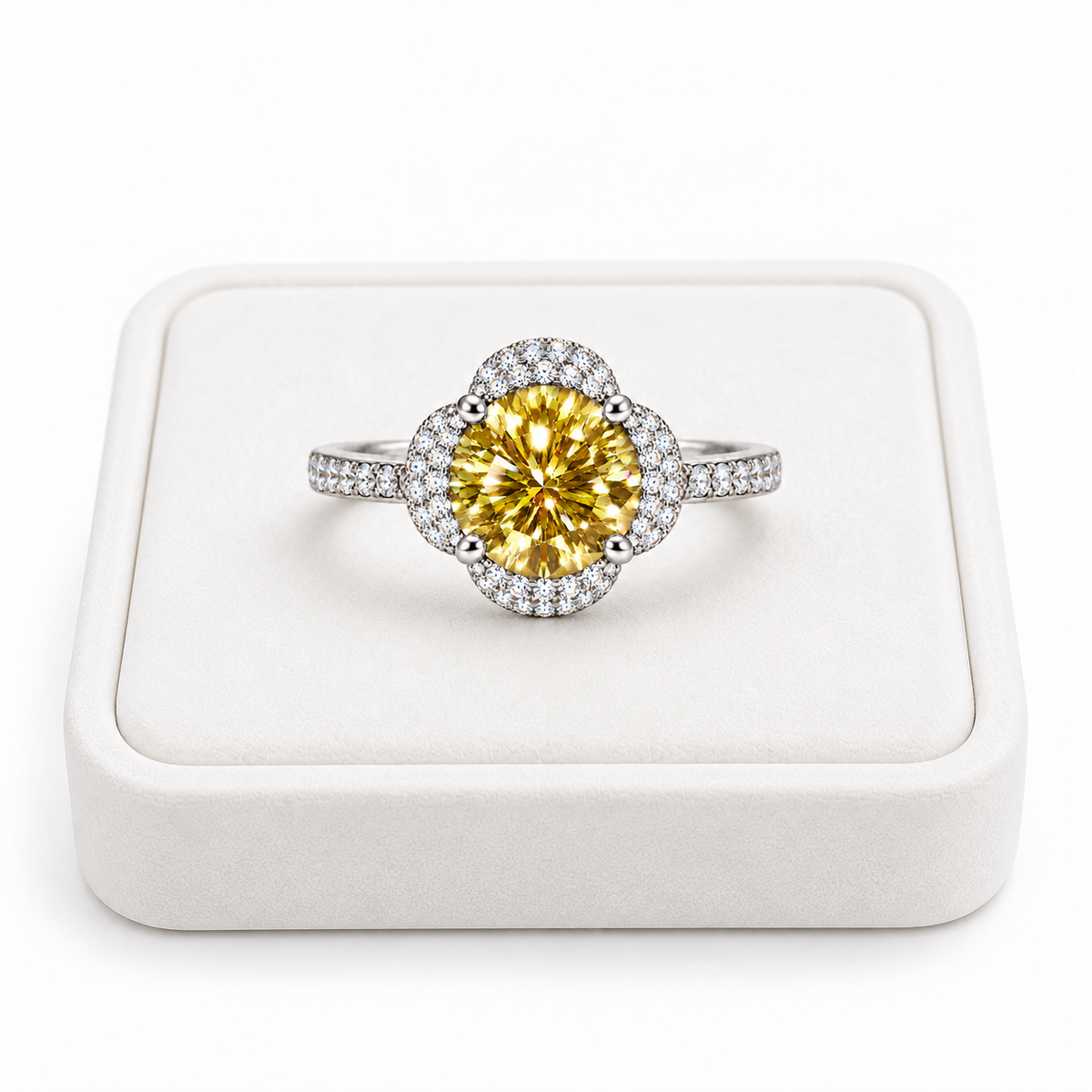 Phimsera 2 carat brilliant yellow moissanite floral halo ring displayed on a premium white velvet jewelry tray against a pure white background with sparkling cubic zirconia accents.