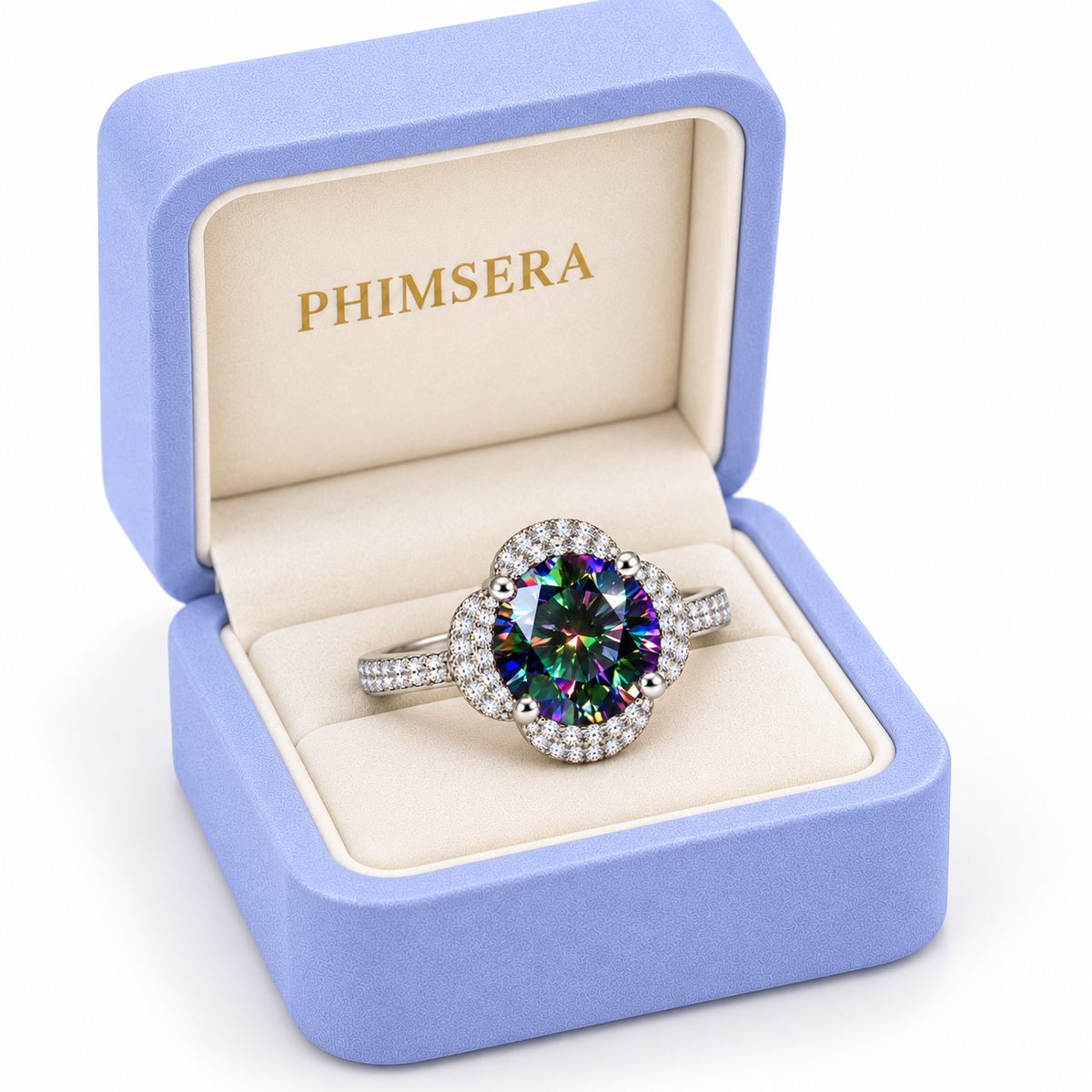Three-quarter view of a 2 carat black rainbow moissanite floral halo ring presented in a slightly turned periwinkle Phimsera jewelry box with cream velvet lining, gold branding and a pure white background.