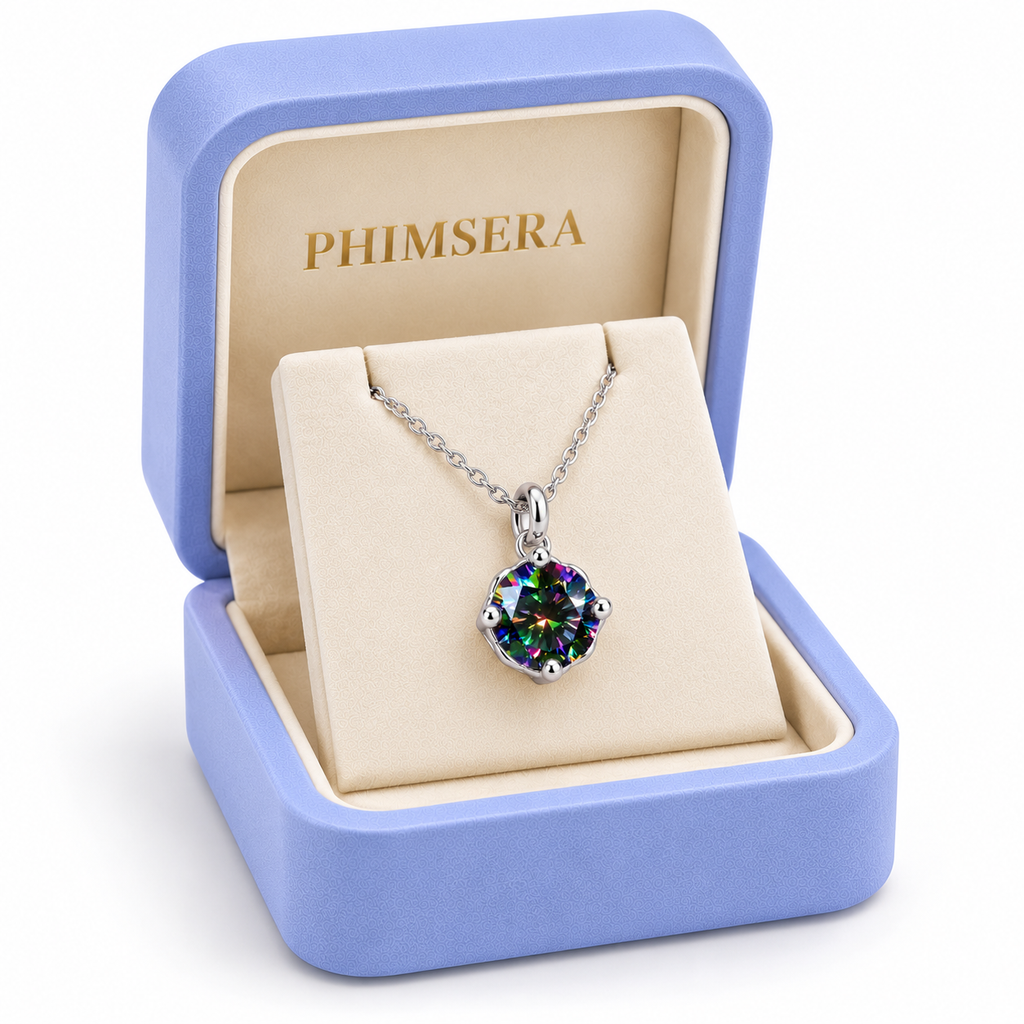 Angled view of a periwinkle Phimsera jewelry gift box containing an 8mm black rainbow moissanite solitaire pendant necklace with a delicate silver chain, ivory jewelry insert, and gold Phimsera branding.