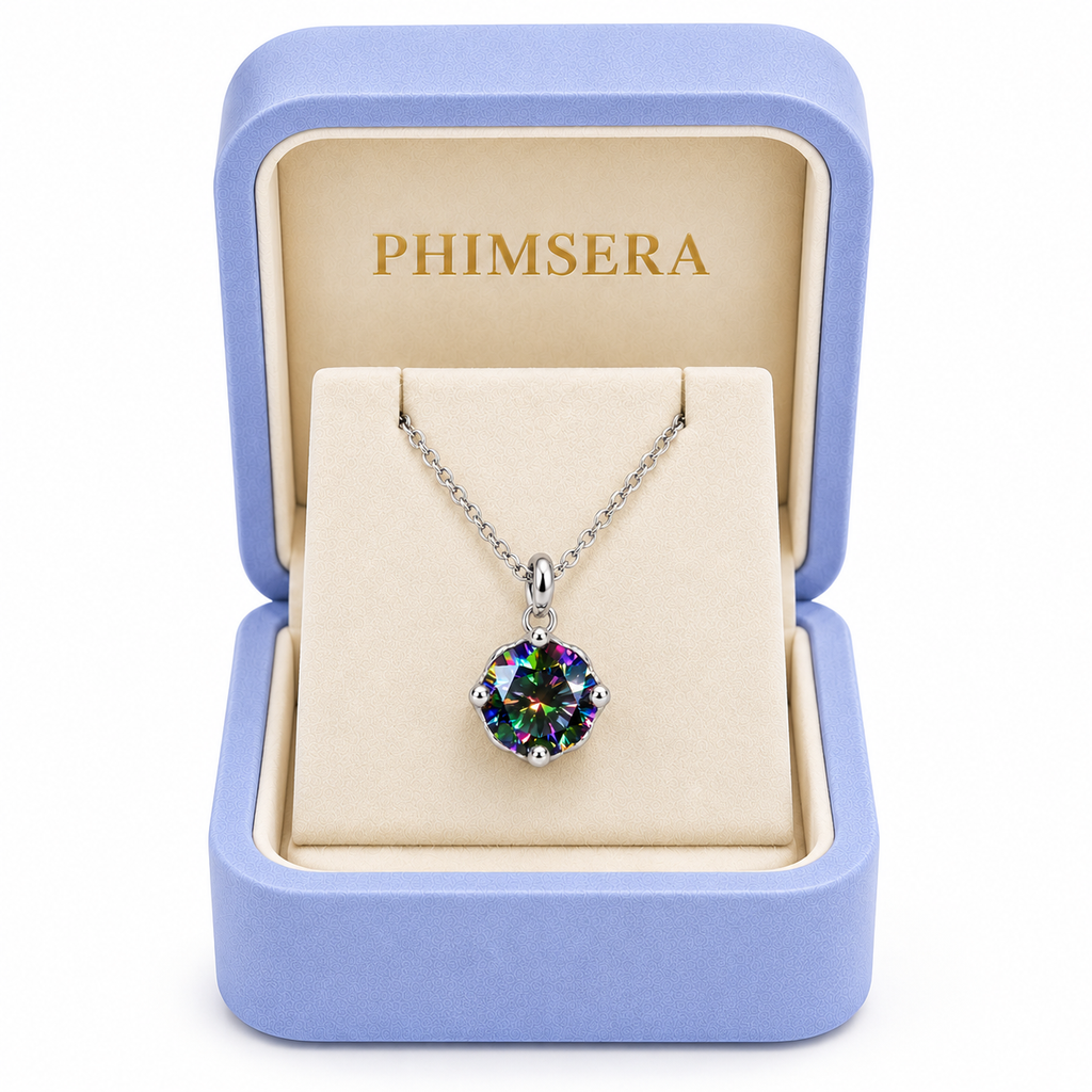 2 carat black rainbow moissanite solitaire necklace displayed inside an open periwinkle Phimsera jewelry gift box with an ivory interior, gold Phimsera logo, and clean white background.