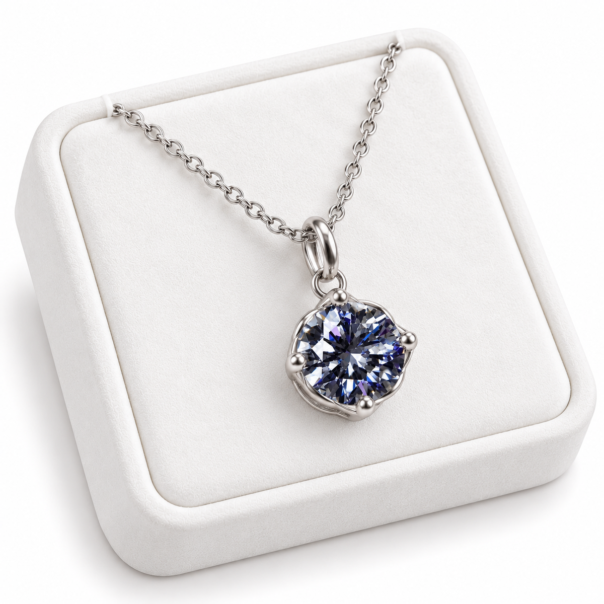 Angled white velvet jewelry tray displaying a 2 carat gray moissanite solitaire necklace with an 8mm round brilliant gemstone and delicate platinum-plated sterling silver chain against a white background.