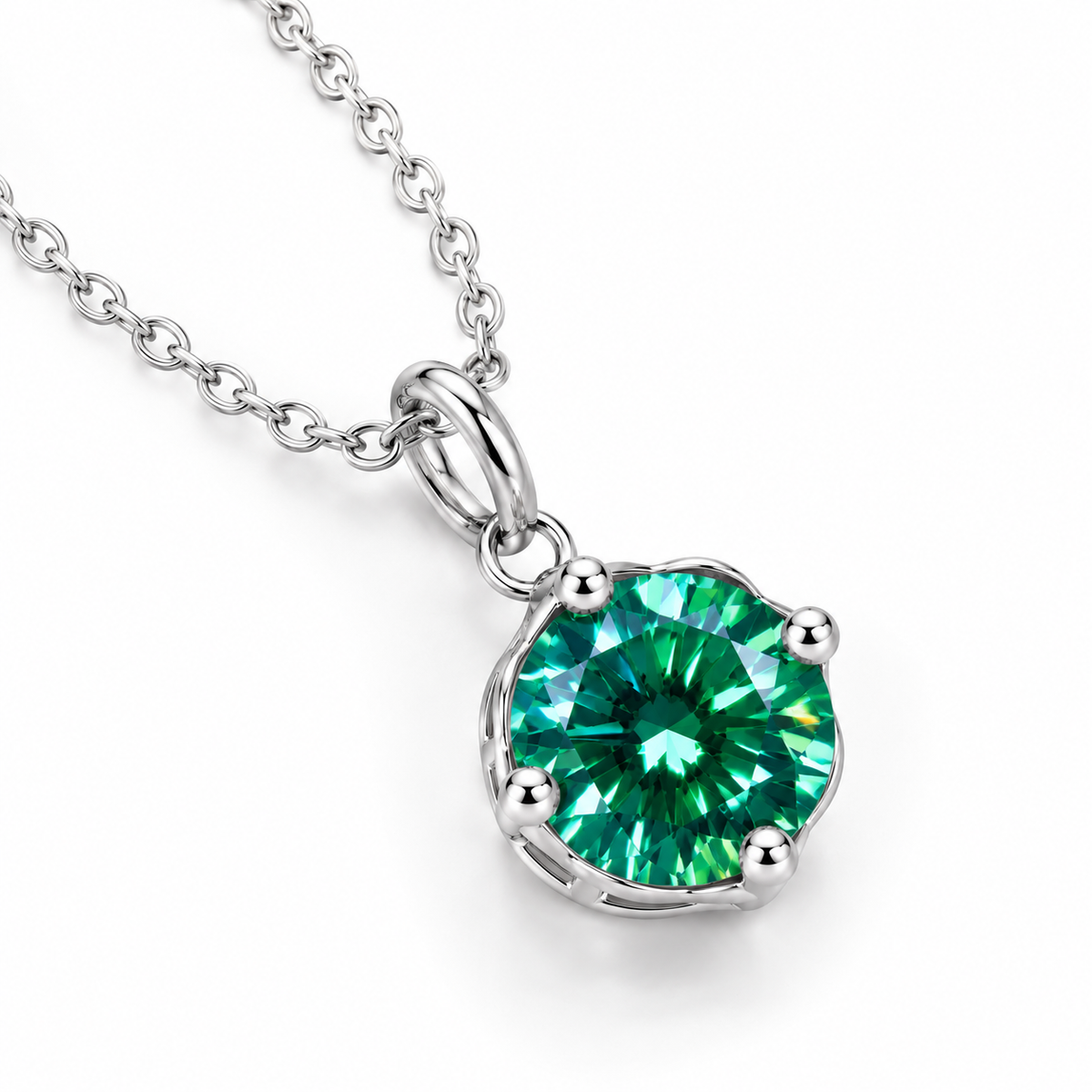 Diagonal product photograph of a 2 carat emerald green moissanite solitaire pendant showing brilliant teal-green reflections, four rounded silver prongs, an elongated oval bail, and a polished sterling silver chain.