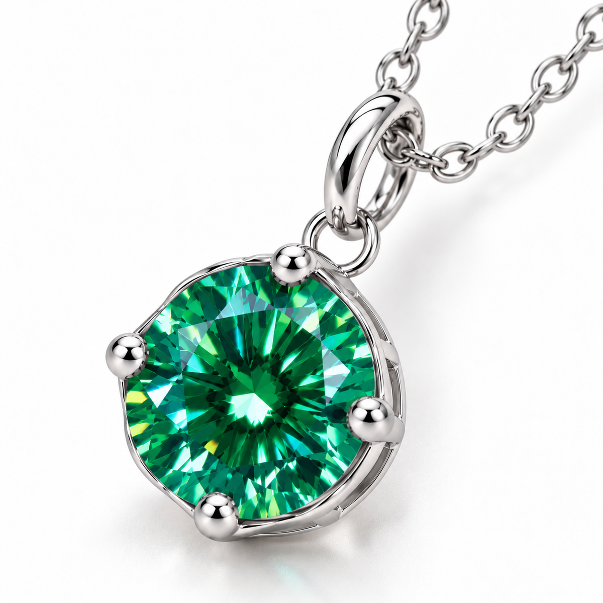 Angled macro photograph of a 2 carat green moissanite pendant highlighting brilliant emerald-green facets, luminous turquoise reflections, four polished silver prongs, and an elegant open solitaire setting.