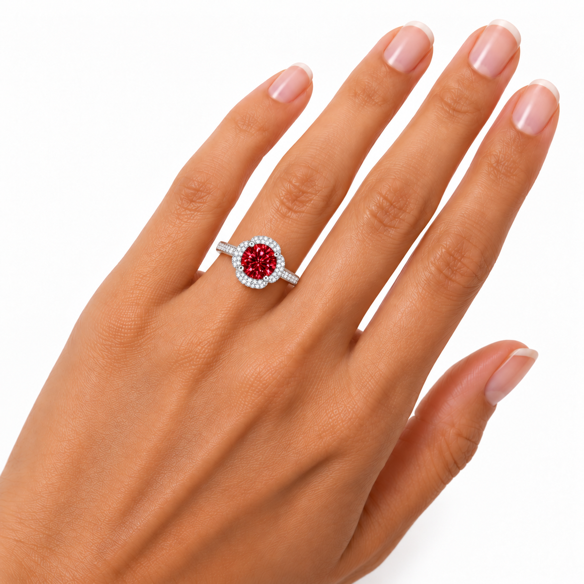 Close-up hand model photograph of an 8mm red moissanite floral halo ring worn on the ring finger, showing realistic gemstone proportions, delicate floral detailing and a slender pavé-accented silver band.