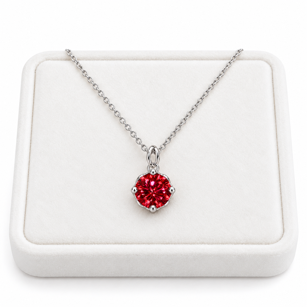 2 carat red moissanite solitaire necklace arranged on a premium white velvet jewelry tray with a delicate sterling silver chain and brilliant 8mm round crimson-red gemstone against a pure white background.