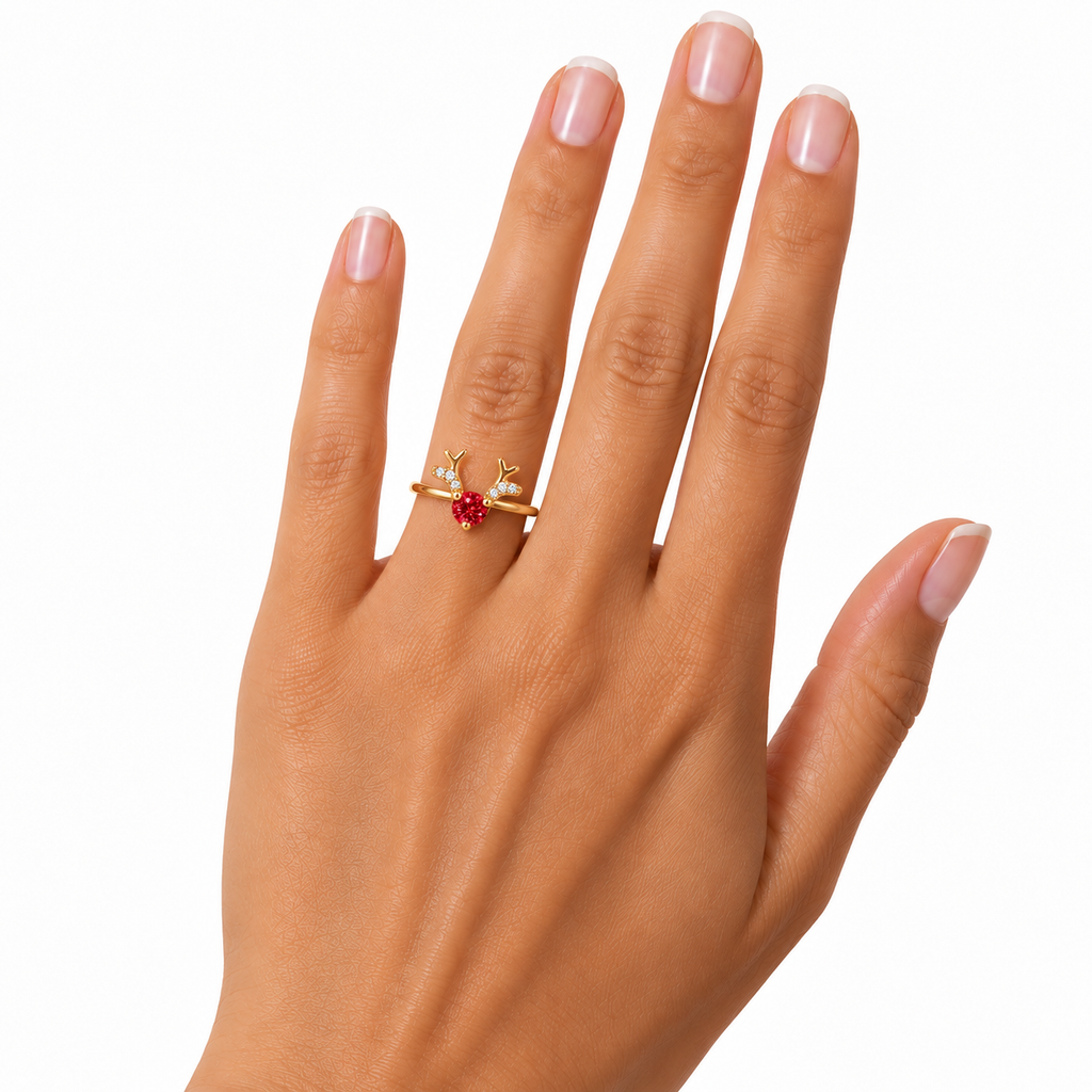 Delicate gold-plated Christmas reindeer antler ring worn on a woman's ring finger, featuring a true-to-size 4mm round red moissanite gemstone and sparkling clear cubic zirconia accents against a white background.