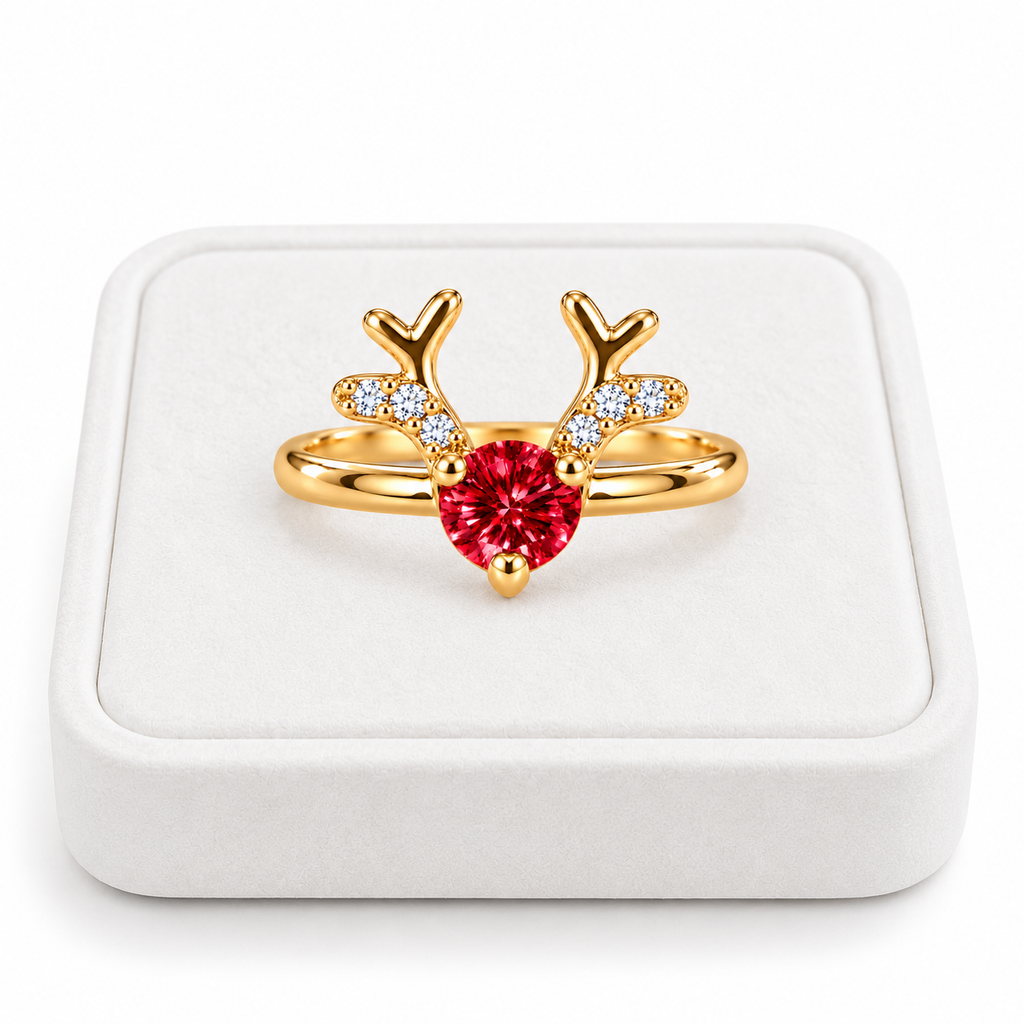 Gold Christmas reindeer antler ring featuring a brilliant 4mm crimson-red moissanite gemstone displayed on a premium white velvet jewelry tray against a pure white background.