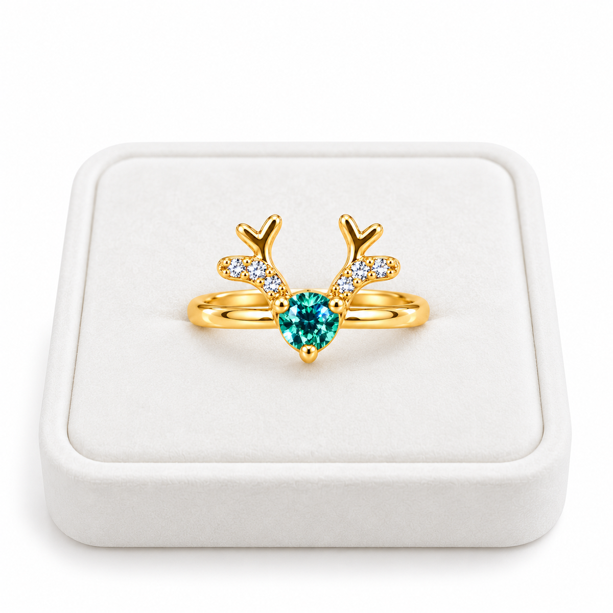Gold Christmas reindeer antler ring featuring a 4mm round teal-green moissanite gemstone displayed on a premium white velvet jewelry tray against a white background.