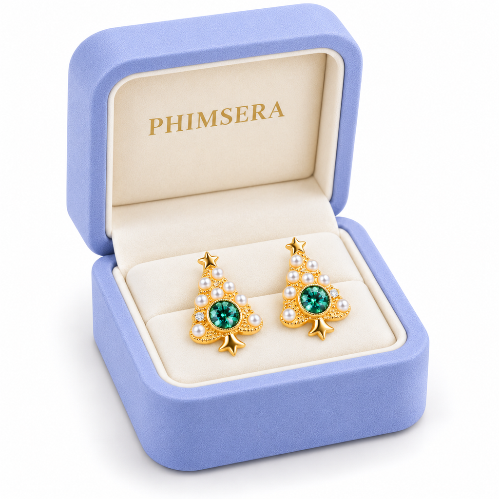 Angled view of gold Christmas tree moissanite earrings inside a periwinkle Phimsera jewelry box with gold branding.