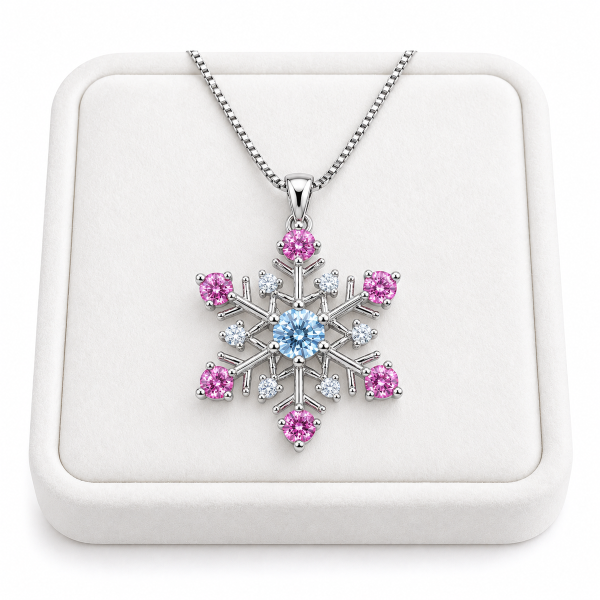 Phimsera icy blue and pink moissanite snowflake necklace displayed on a premium white velvet jewelry tray against a pure white background, featuring a brilliant blue center stone, six pink moissanite gemstones and sparkling silver snowflake design.