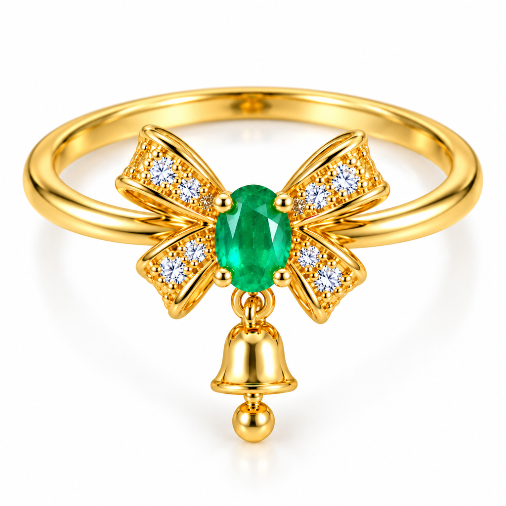 Elevated view of a delicate natural emerald bow ring featuring a 3x4mm oval green gemstone, four gold ribbon sections with clear CZ accents and a dangling polished gold bell on a white background.