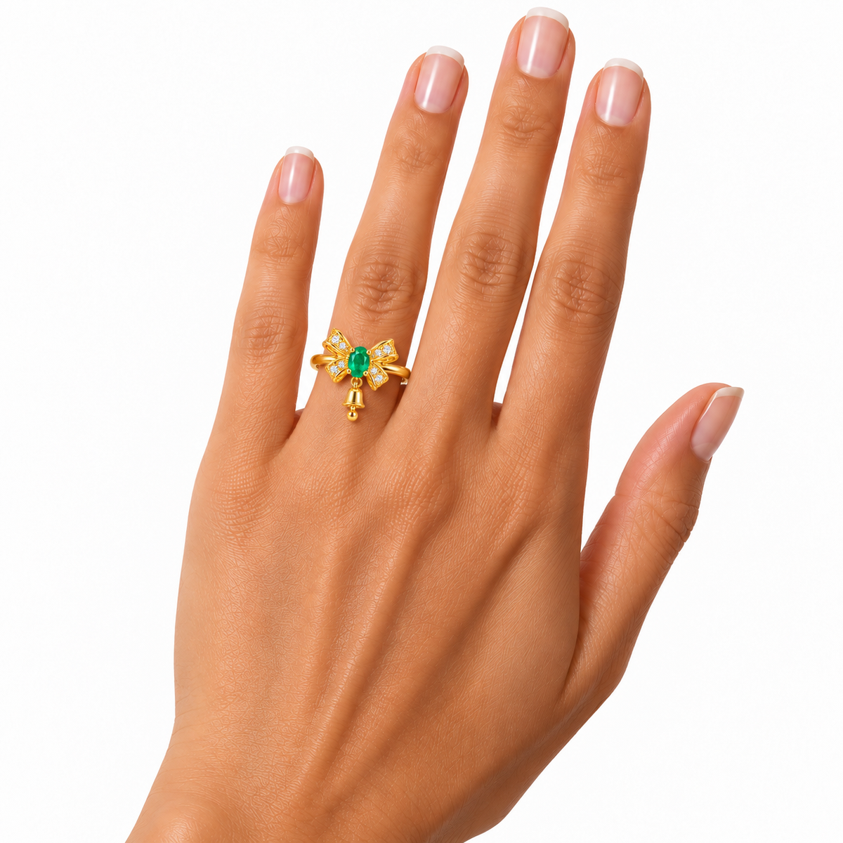Front view of a delicate gold-plated sterling silver emerald bow ring worn on a woman's ring finger, featuring a small 3x4mm oval natural emerald and miniature hanging Christmas bell on a white background.