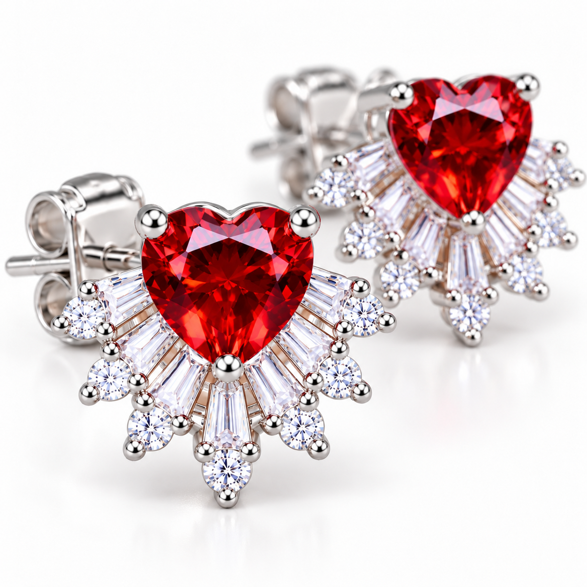 Angled macro photograph of natural 6mm red garnet heart stud earrings highlighting deep crimson gemstone facets, brilliant baguette and round cubic zirconia accents, and detailed polished silver prong settings.