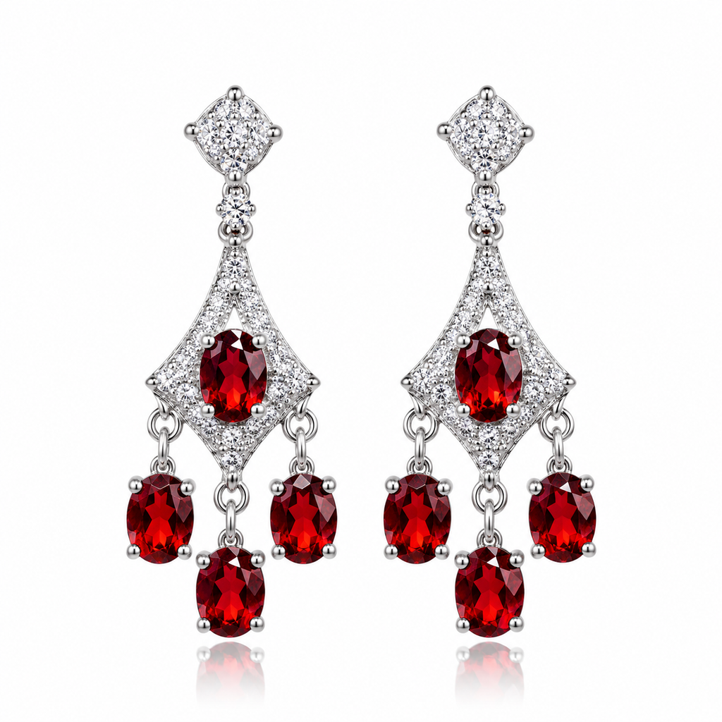Natural red garnet chandelier dangle earrings featuring eight oval 4x5mm crimson-red gemstones, sparkling clear cubic zirconia accents, decorative geometric frames, and polished 925 sterling silver settings against a pure white background.