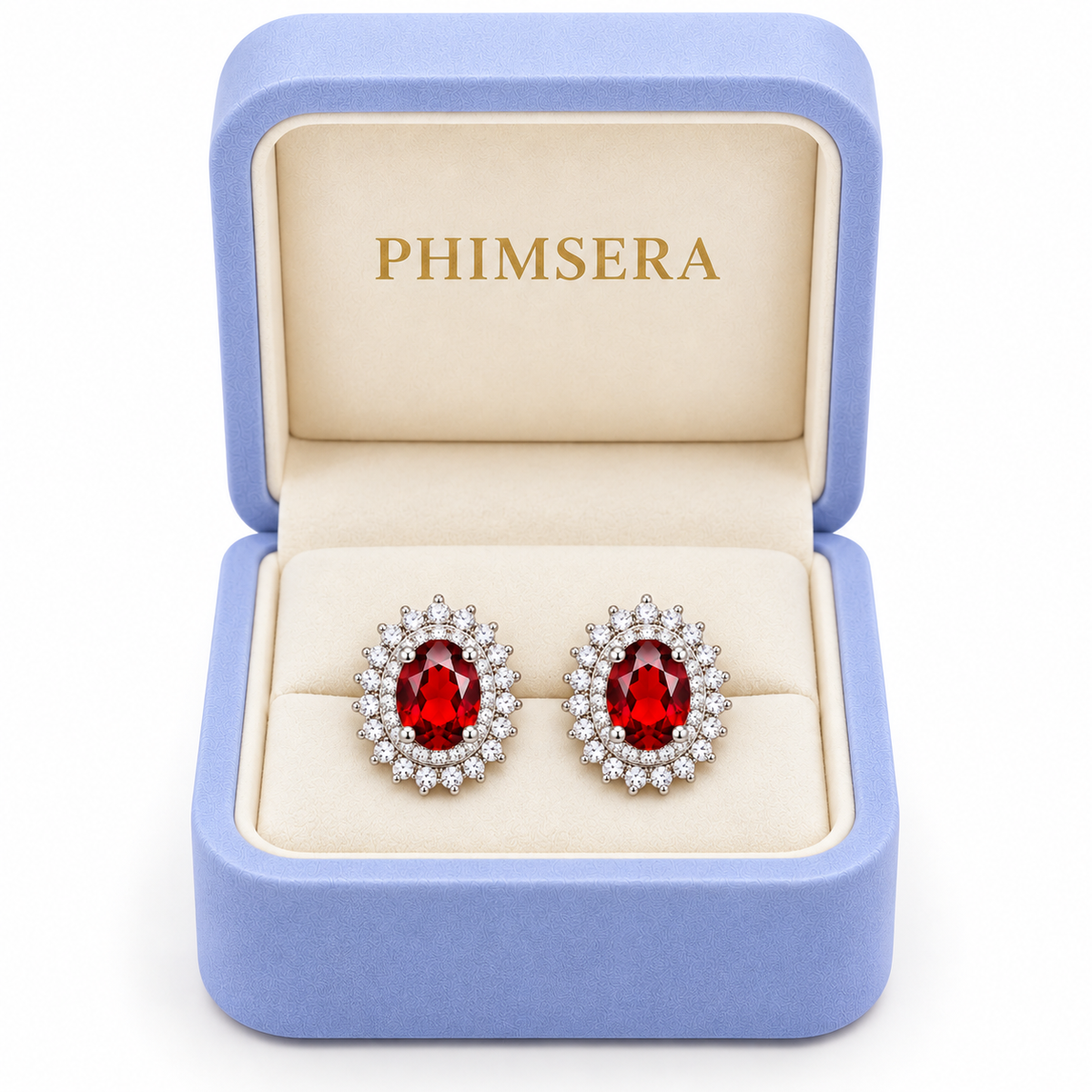 Natural red garnet double halo stud earrings displayed inside an open periwinkle Phimsera jewelry gift box with an ivory interior and gold Phimsera logo, featuring 5x7mm oval crimson gemstones and sparkling cubic zirconia halos against a white background.