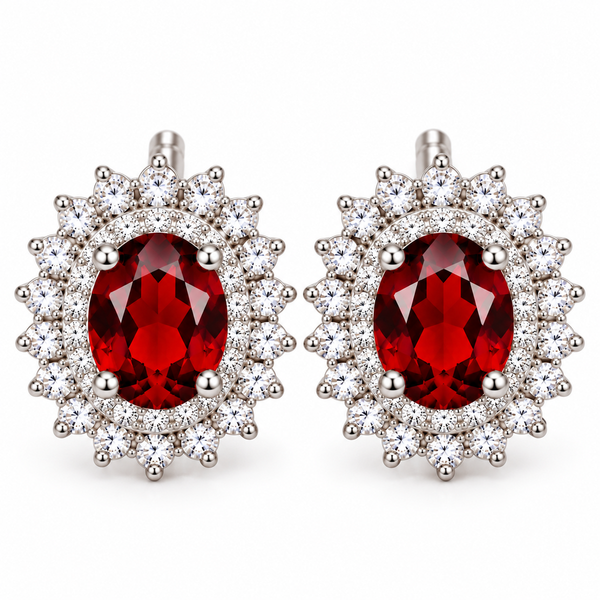 Detailed macro of natural 5x7mm red garnet double halo stud earrings highlighting deep crimson gemstone facets, sparkling clear cubic zirconia, polished sterling silver four-prong settings, and decorative sunburst borders.