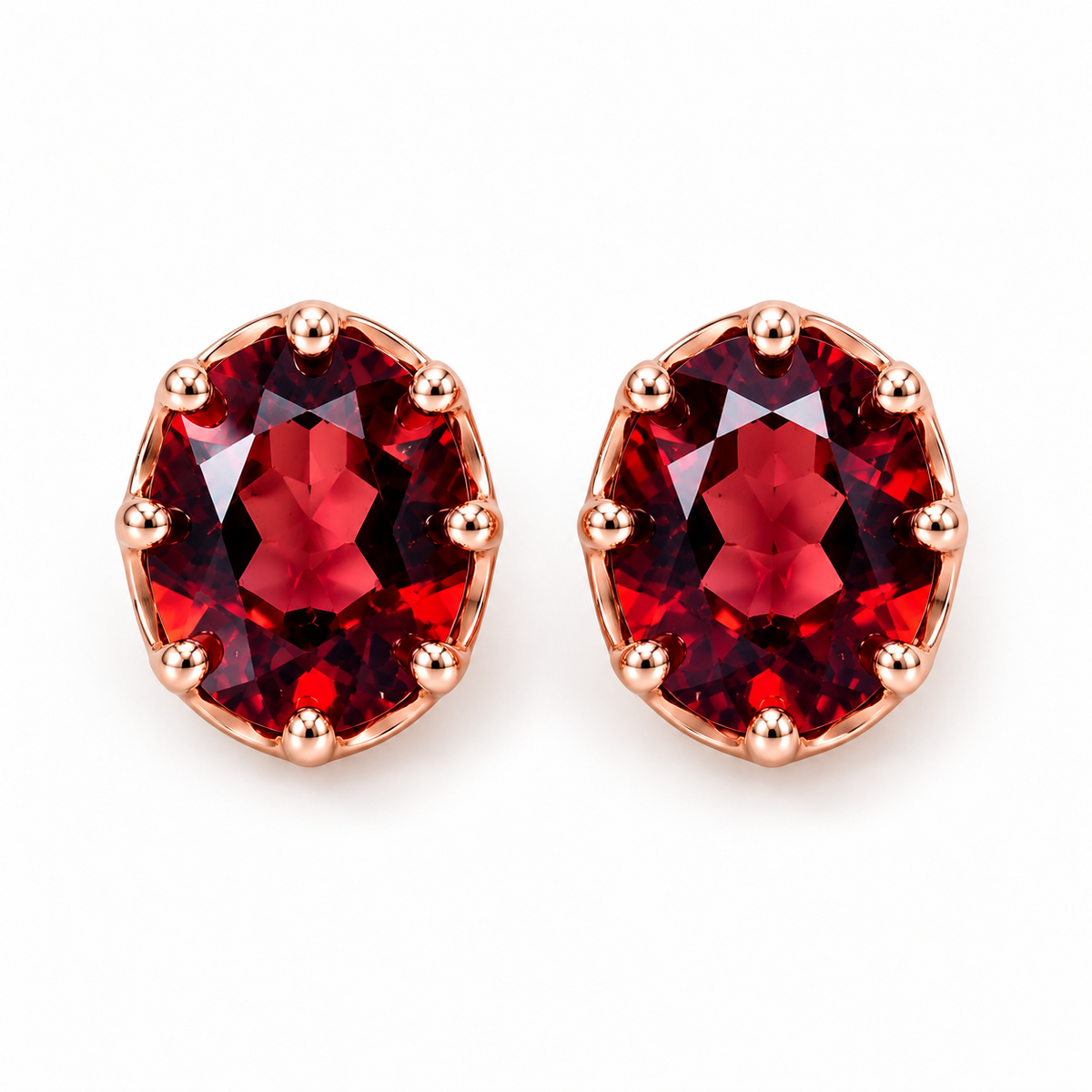 Top-down photograph of matching natural red garnet oval stud earrings with 6x8mm faceted gemstones, deep wine-red reflections, and symmetrical rose gold plated sterling silver settings against a pure white background.