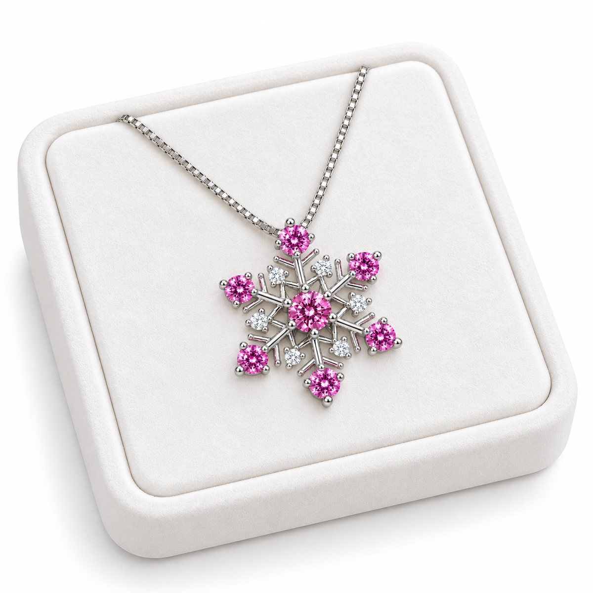 Angled white velvet tray presentation of a pink moissanite snowflake necklace featuring seven vibrant pink gemstones, six sparkling white cubic zirconia accents and a silver chain.