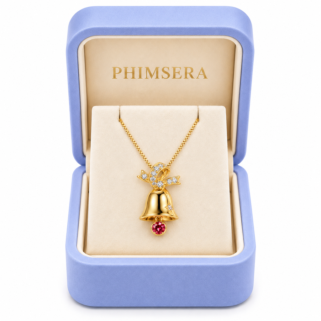 Red moissanite Christmas bell necklace displayed inside an open periwinkle Phimsera jewelry gift box with ivory velvet interior and gold PHIMSERA lettering against a pure white background.