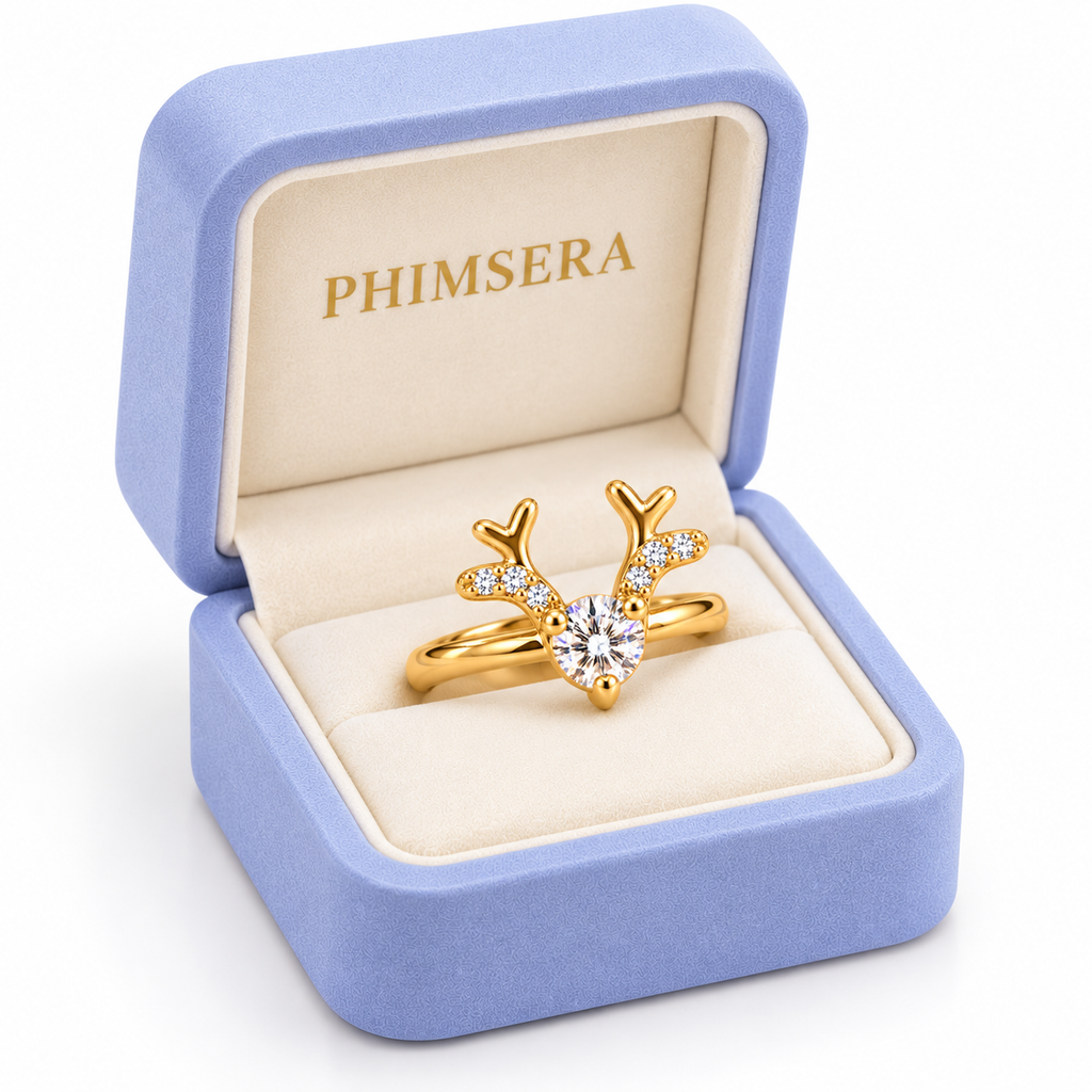 Angled view of a periwinkle Phimsera jewelry box displaying a gold Christmas reindeer ring with a brilliant 4mm round white moissanite center gemstone.