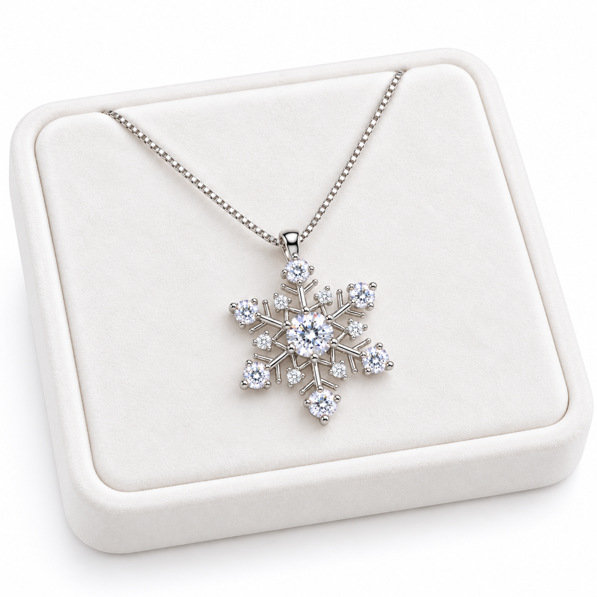 Angled presentation of a white moissanite snowflake necklace on a slightly turned white velvet jewelry tray, showcasing the delicate silver chain, seven brilliant moissanite gemstones and six white CZ accents.