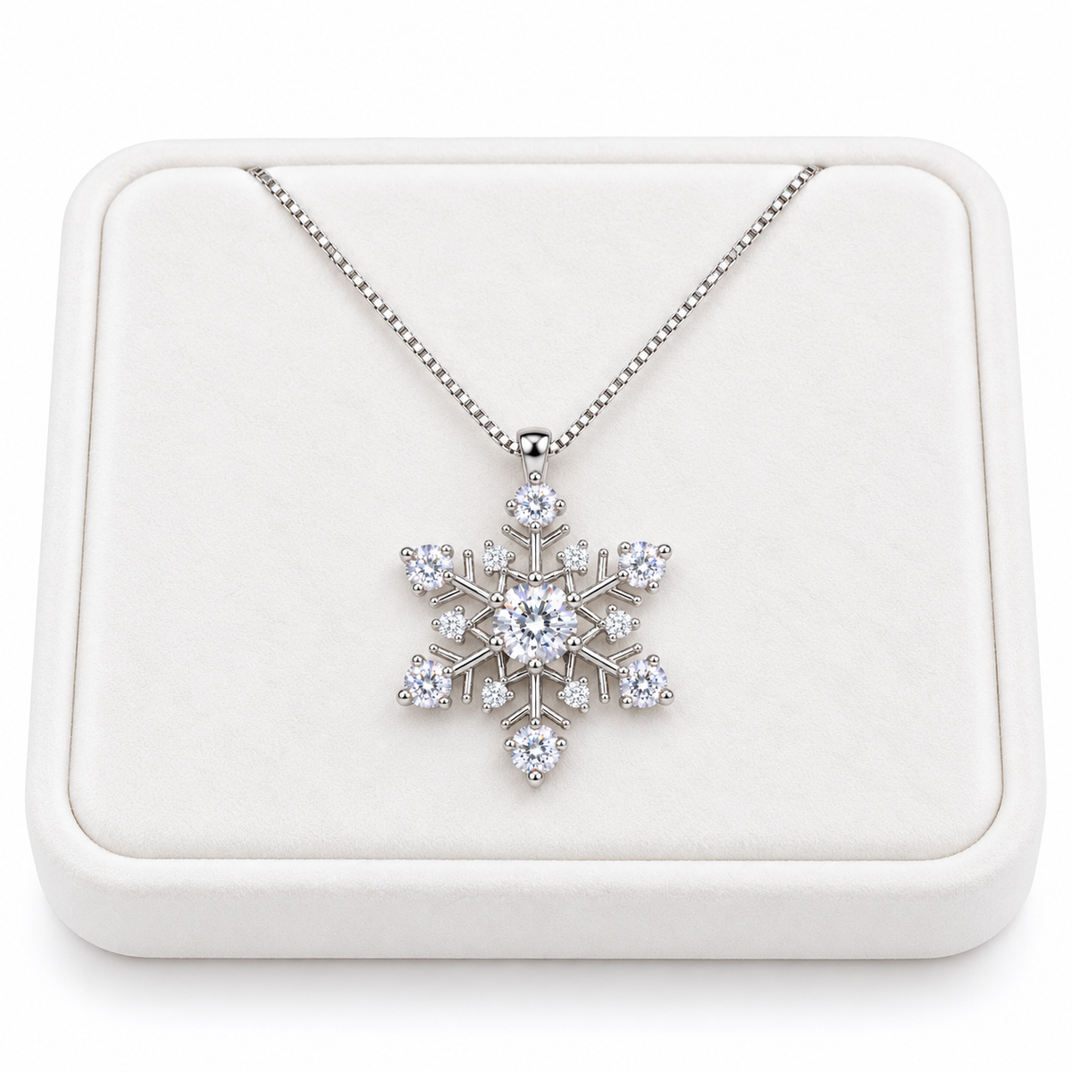 White moissanite snowflake pendant necklace displayed on a premium white velvet jewelry tray against a pure white background, featuring a delicate sterling silver chain and sparkling white gemstones.