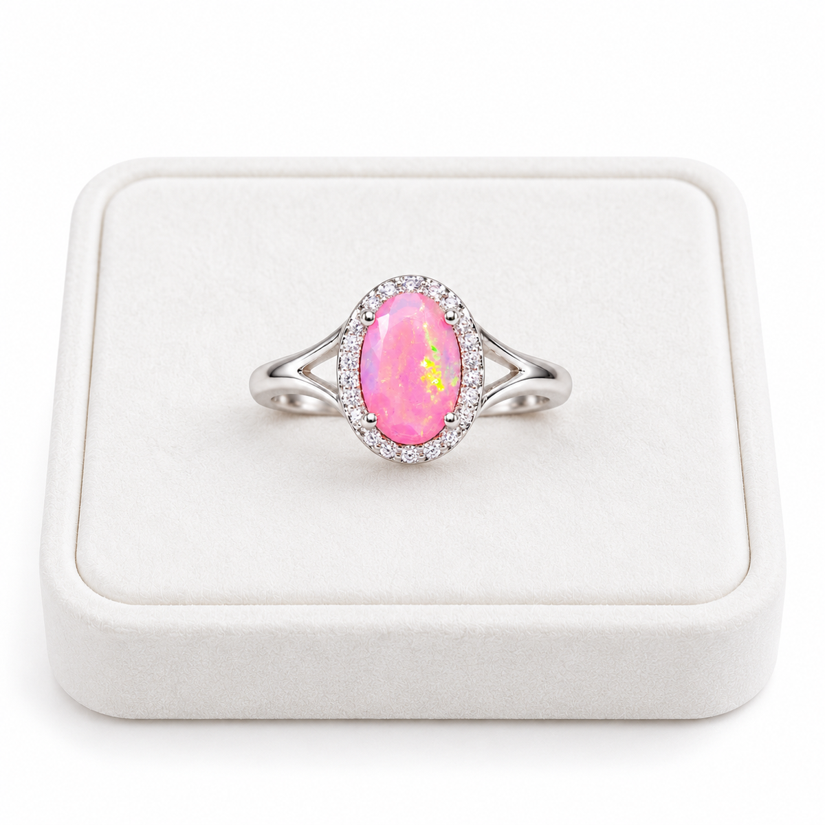 Pink fire opal ring displayed on a white velvet jewelry tray against a clean white background.