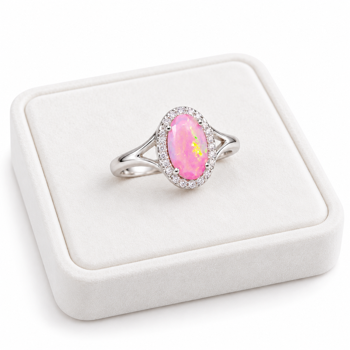 Pink fire opal ring displayed on a white velvet jewelry tray against a clean white background.